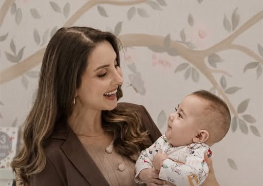 Dra. Suelen segurando um bebê sorridente no colo