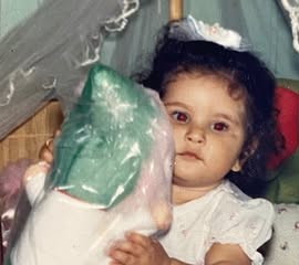 Suelen ainda bebê, brincando entre bonecas e bichos de pelúcia