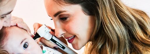 Dra. Suelen examinando o ouvido de um bebê com otoscópio
