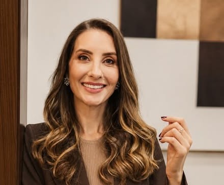 Dra. Suelen Dagostin sorrindo, de blazer marrom